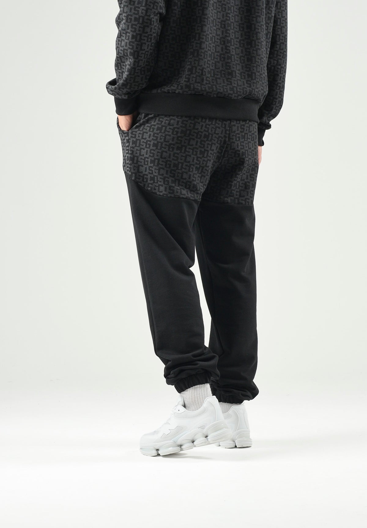 GCDS Pantaloni casual neri per uomo e donna con coulisse in vita e inserti monogramma jacquard a contrasto. C2MWQI122F245 999I GCDS