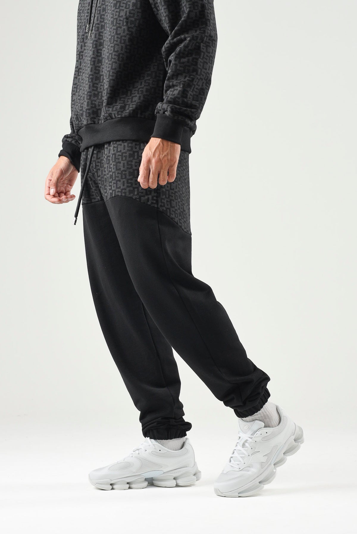 GCDS Pantaloni casual neri per uomo e donna con coulisse in vita e inserti monogramma jacquard a contrasto. C2MWQI122F245 999I GCDS