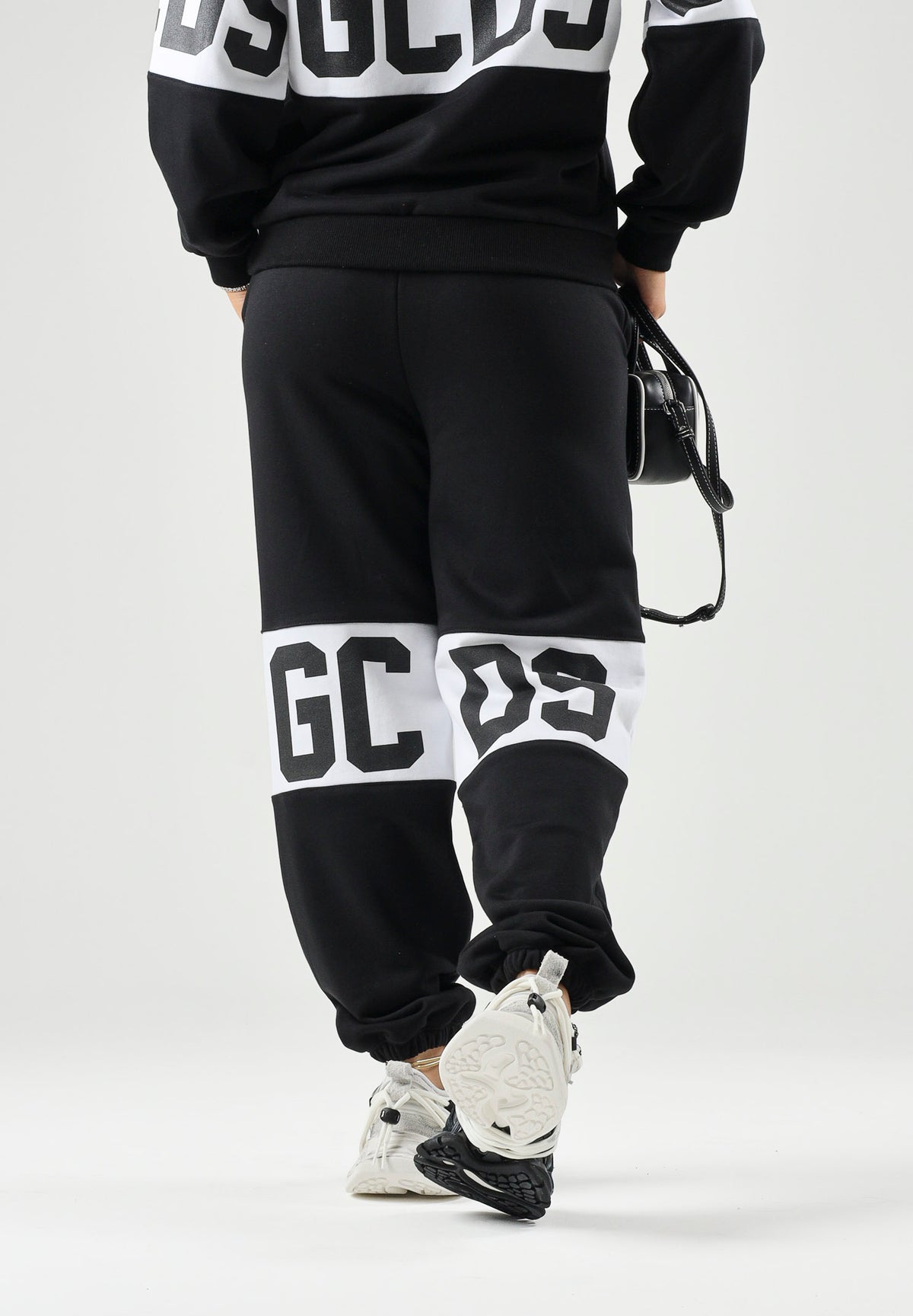 GCDS Pantaloni BAND LOGO TRACK PANTS neri per donna, ragazzi e bambini con fascia e maxi logo GCDS a contrasto. Z0UJQI588F004 999A GCDS