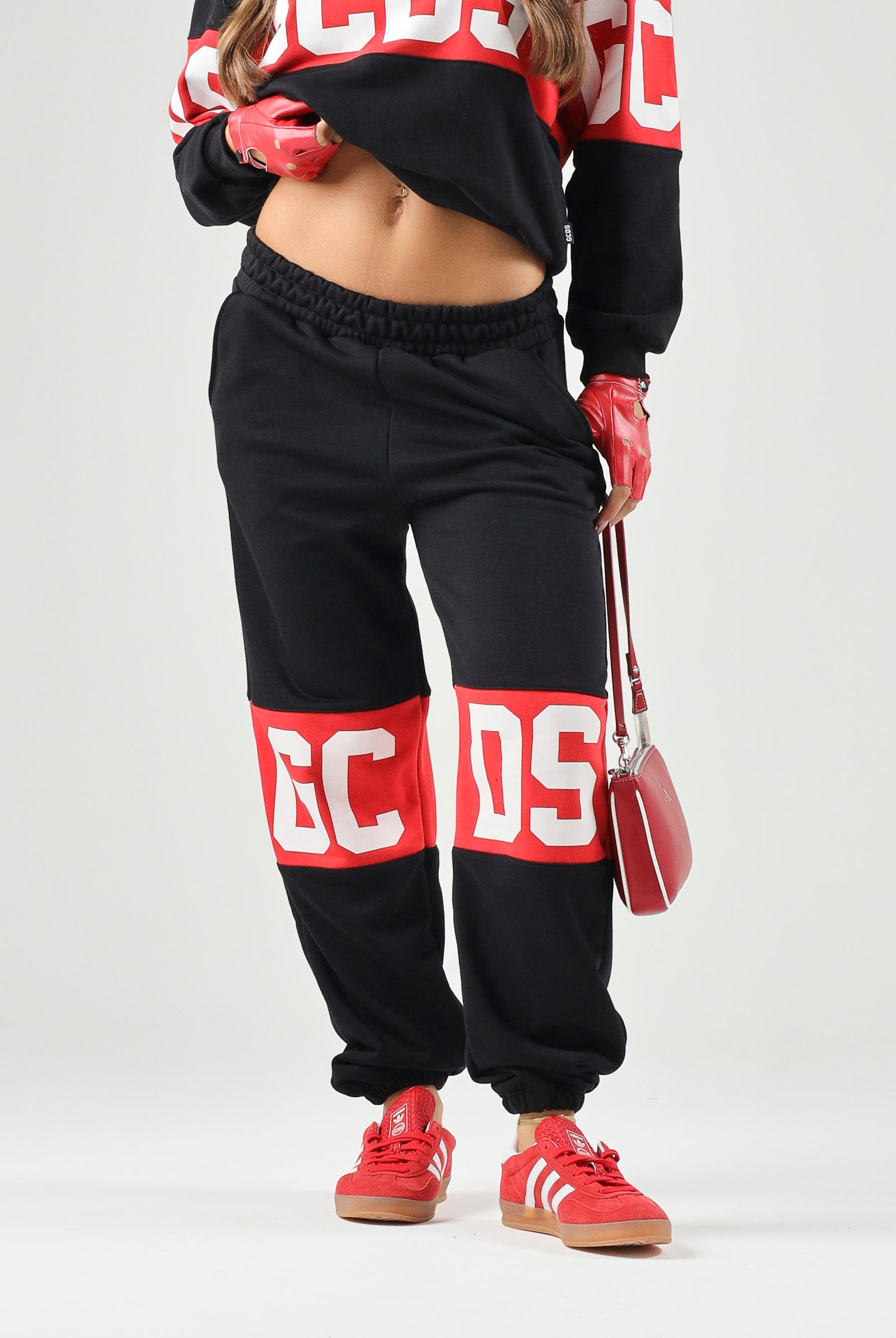 GCDS Pantaloni BAND LOGO TRACK PANTS nero/rosso per donna, ragazzi e bambini con maxi logo GCDS a contrasto. Z0UJQI588F004 999R GCDS