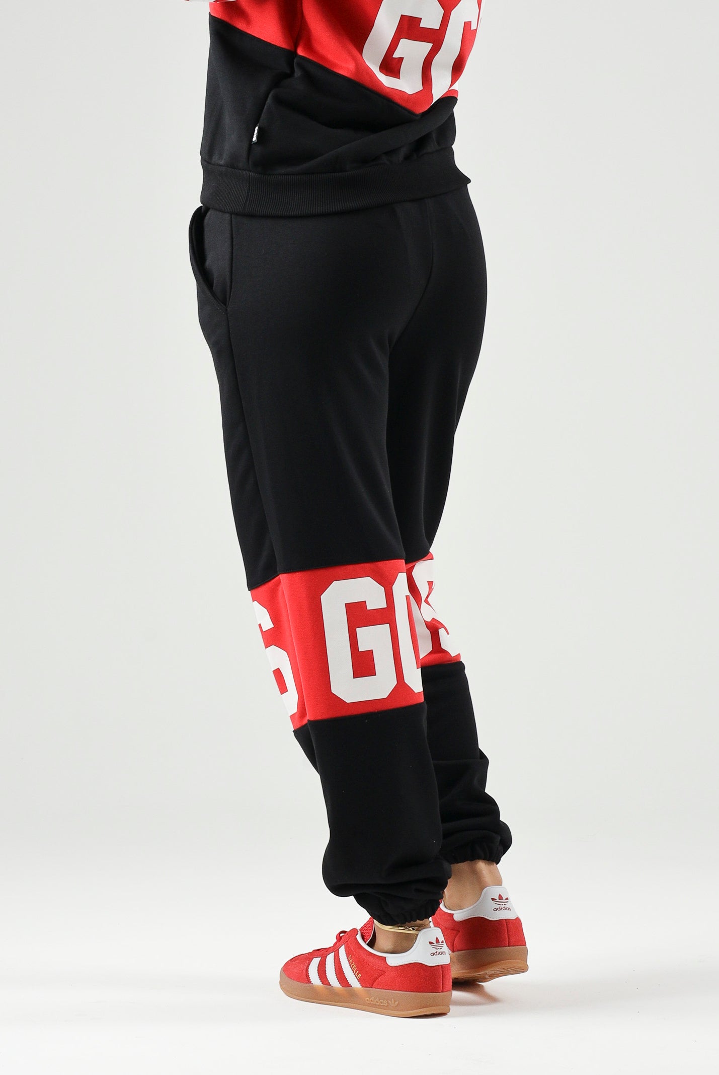 GCDS Pantaloni BAND LOGO TRACK PANTS nero/rosso per donna, ragazzi e bambini con maxi logo GCDS a contrasto. Z0UJQI588F004 999R GCDS
