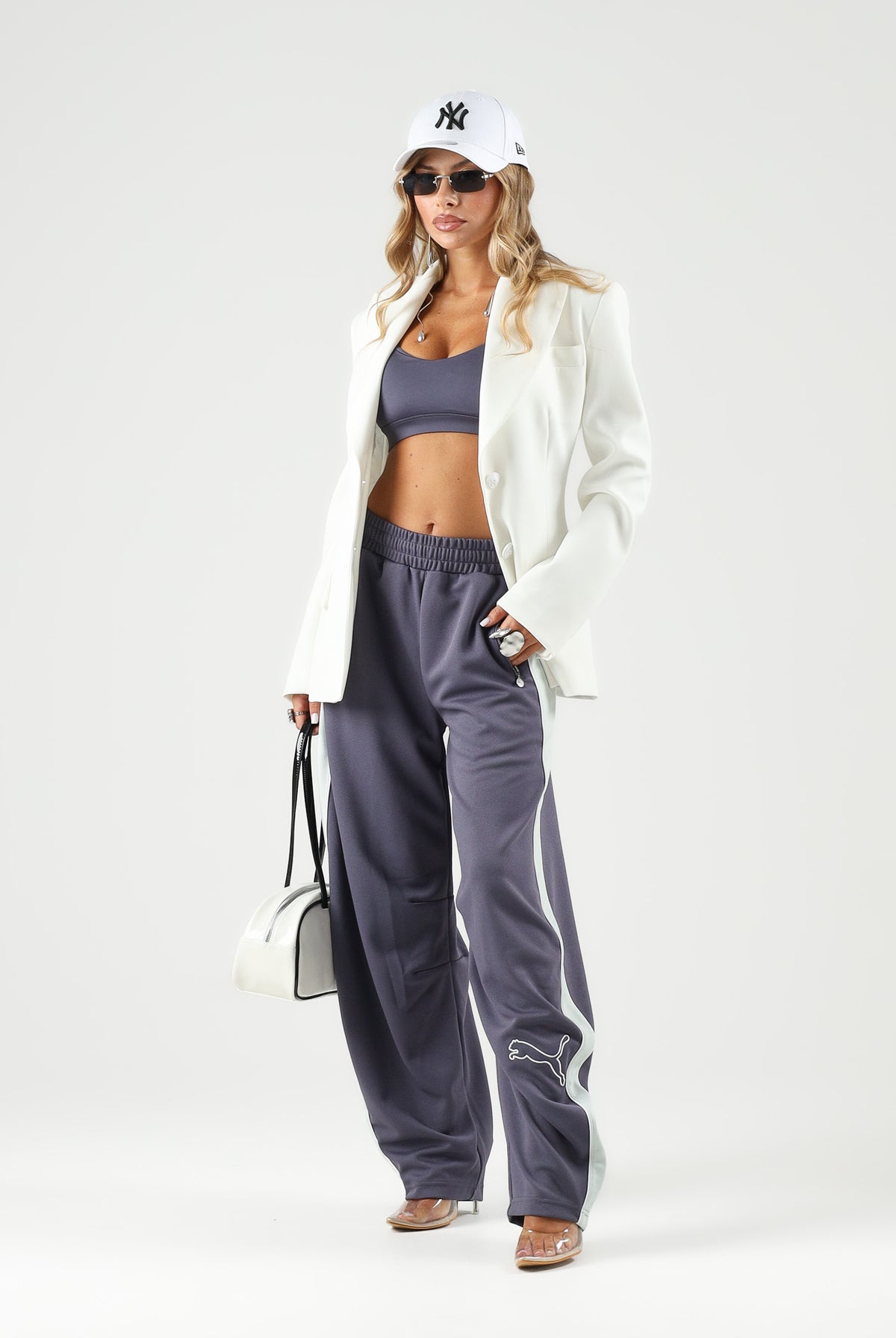 PUMA Pantalone DARE TO WOVEN grigio antracite per donna con bande laterali bianche, tasche zippate e gamba ampia. 636633 35 PUMA