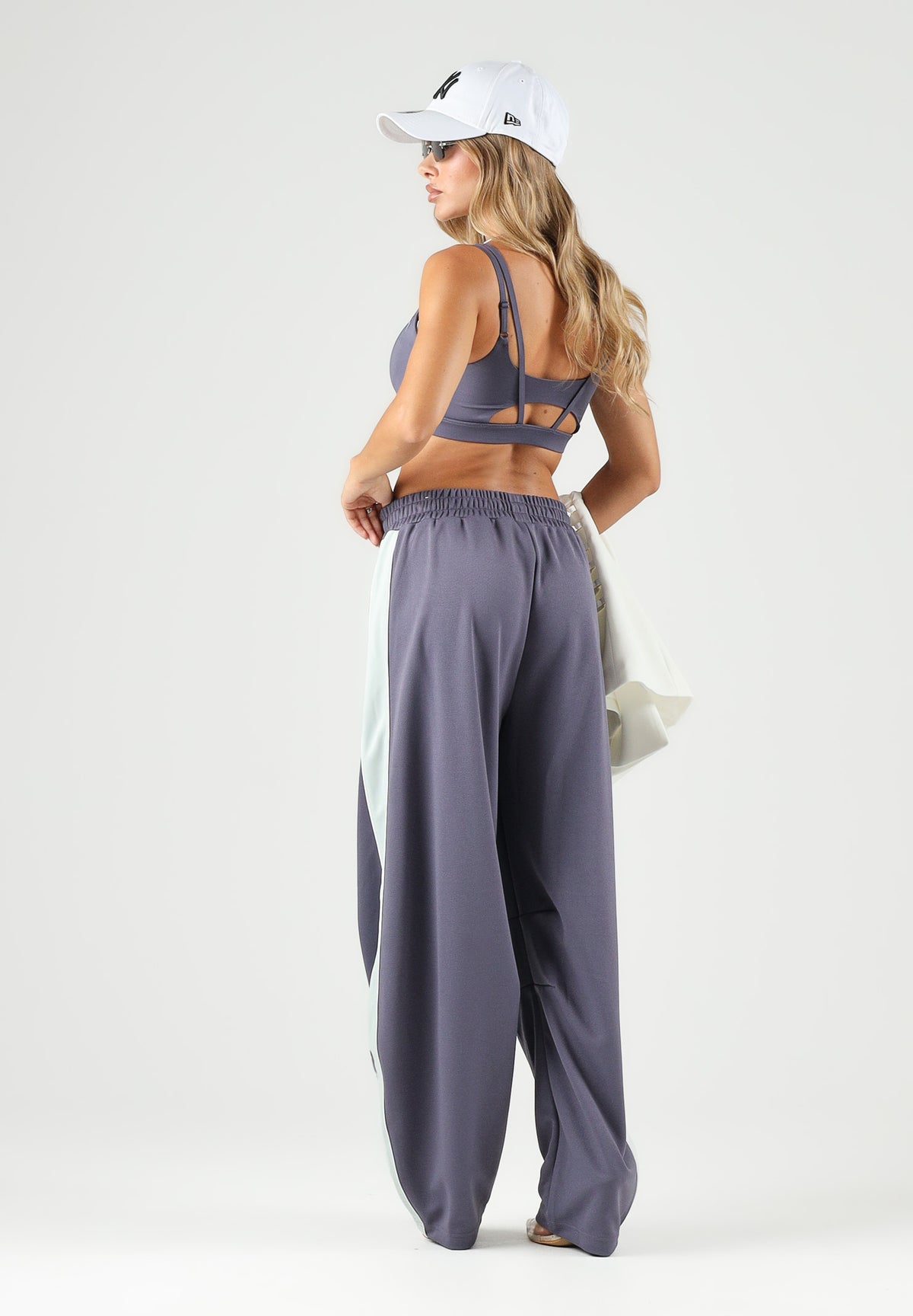 PUMA Pantalone DARE TO WOVEN grigio antracite per donna con bande laterali bianche, tasche zippate e gamba ampia. 636633 35 PUMA