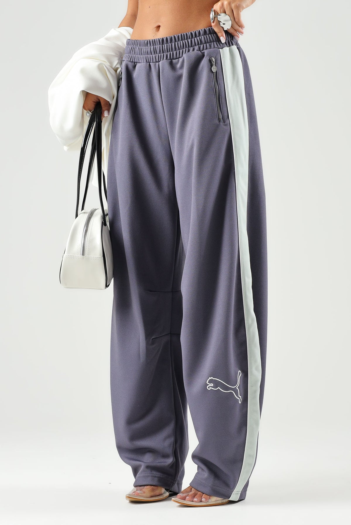 PUMA Pantalone DARE TO WOVEN grigio antracite per donna con bande laterali bianche, tasche zippate e gamba ampia. 636633 35 PUMA