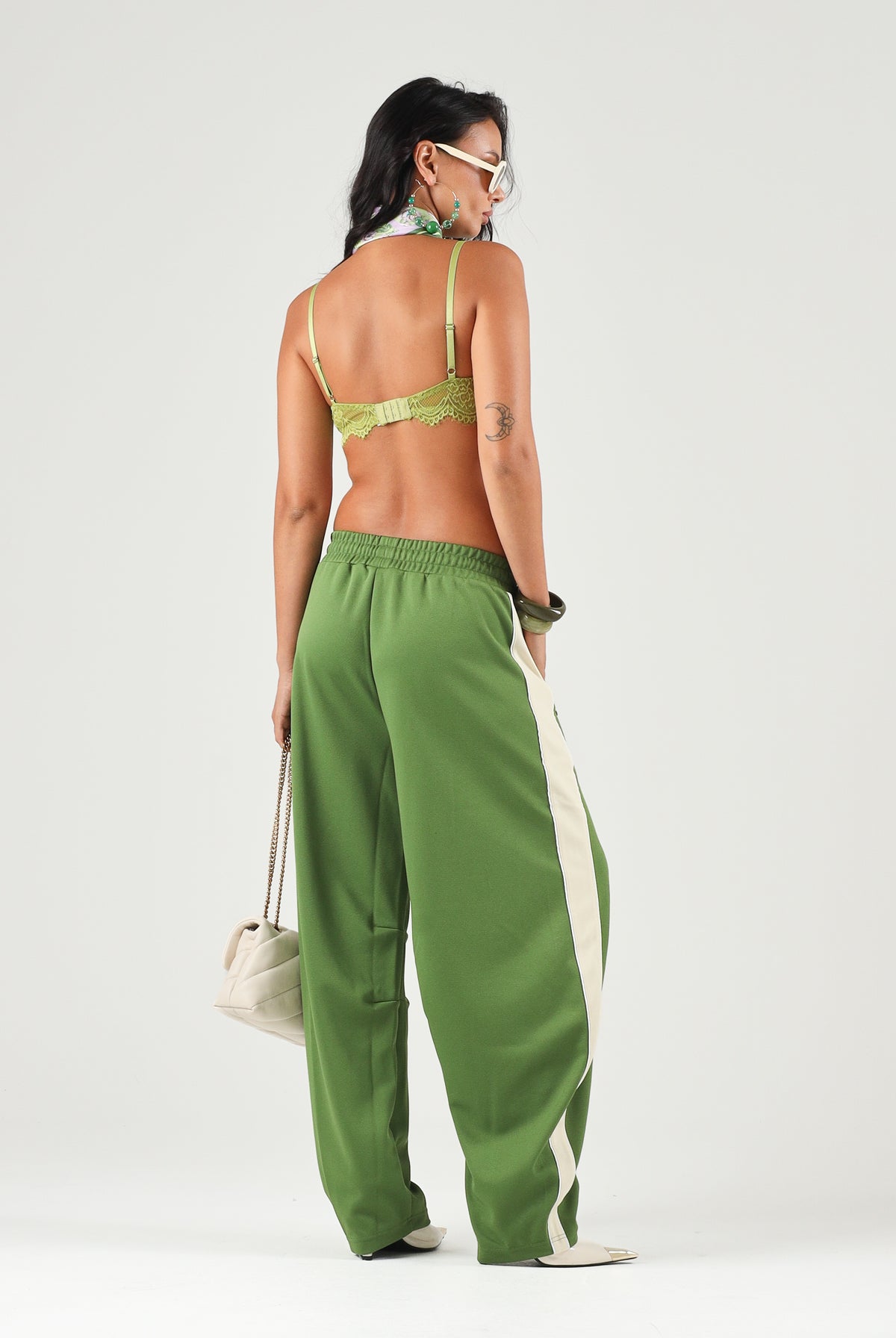 PUMA Pantaloni DARE TO WOVEN verdi per donna con bande laterali bianche, tasche zippate e gamba ampia. 636633 68 PUMA