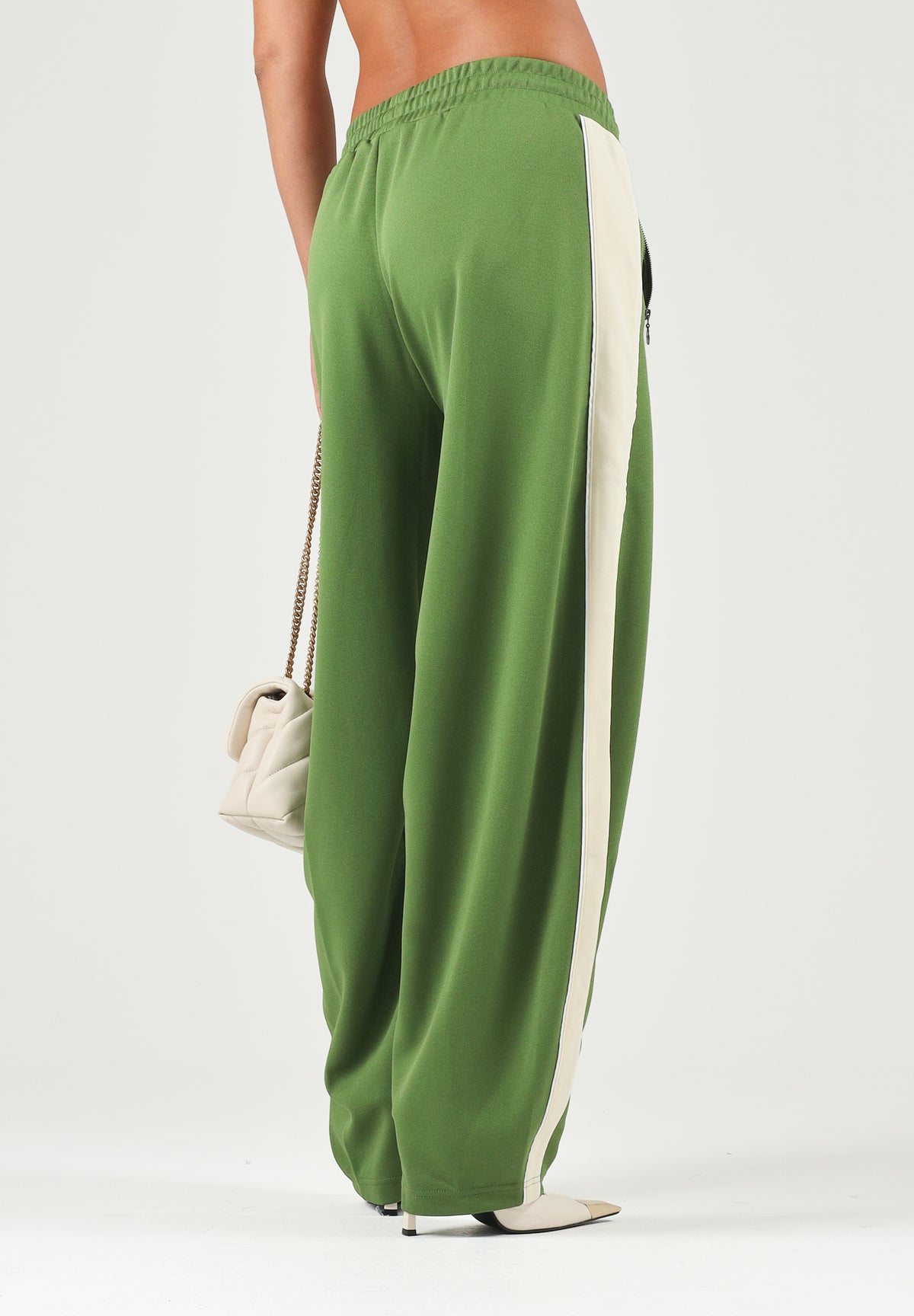 PUMA Pantalone DARE TO WOVEN verde per donna con bande laterali bianche, tasche zippate e gamba ampia. 636633 68 PUMA