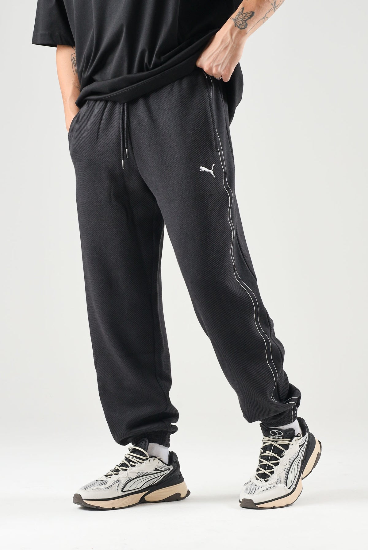 PUMA Pantaloni TRACK PANTS neri da uomo con profili laterali e fondo con polsino. 694300 01 PUMA