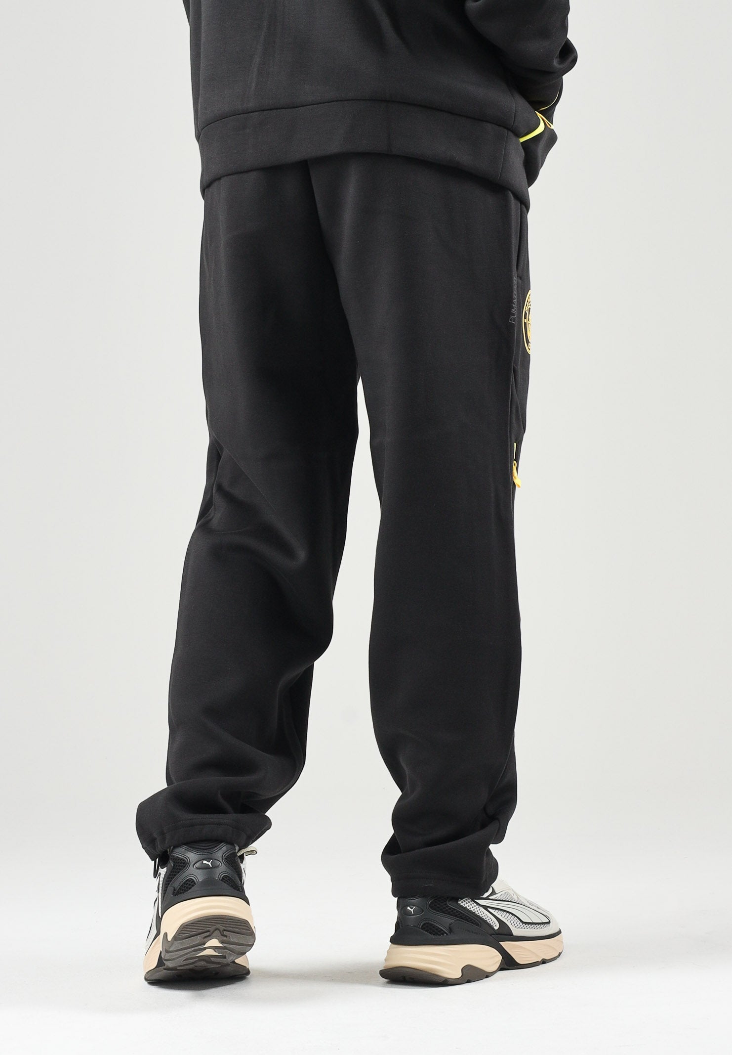 PUMA Pantaloni MANCHESTER CITY TRAVEL PANTS nero da uomo con zip dorata e stemma del club applicato. 786265 27 PUMA