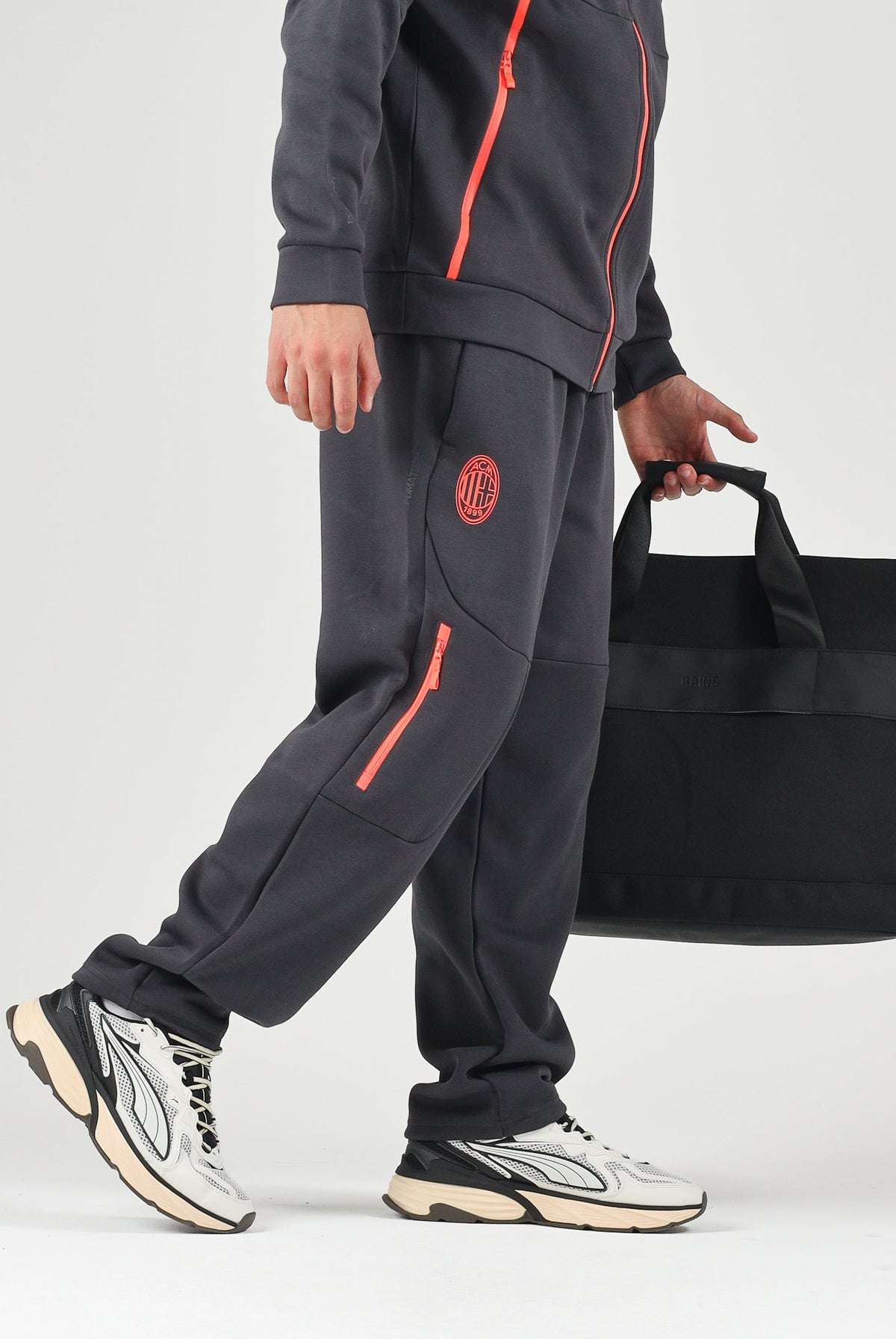 PUMA Pantaloni AC MILAN TRAVEL PANTS neri da uomo con tasca zippata rossa a contrasto e stemma del club. 786686 20 PUMA
