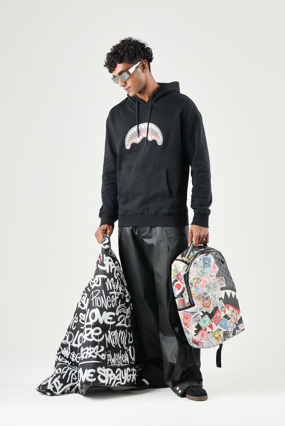 SPRAYGROUND Felpa con cappuccio nero per uomo e donna con tasca centrale e iconico dettaglio grafico frontale. SP946GBLK . SPRAYGROUND