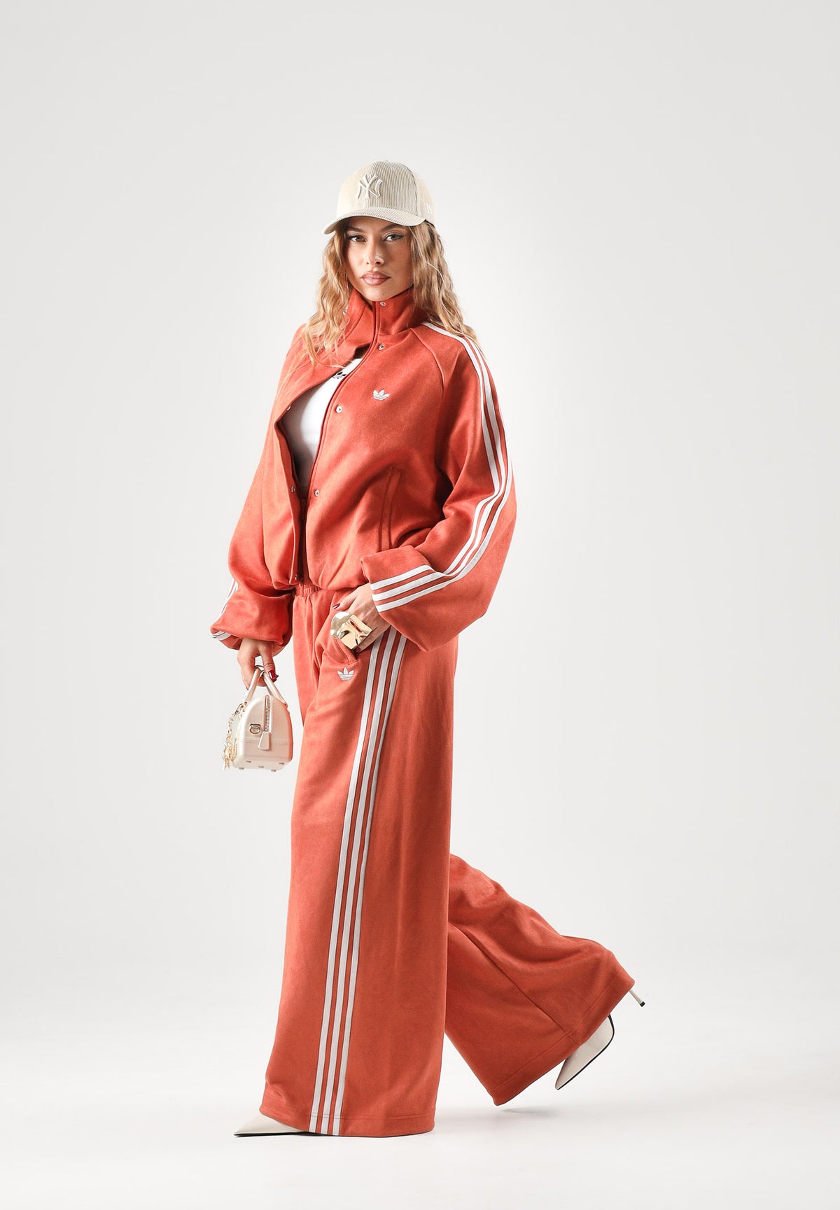 ADIDAS ORIGINALS Pantaloni ADILENIUM SEASON 6 FAUX SUEDE TRACK PANT arancione terracotta da donna, in tessuto effetto camoscio sintetico, con tre strisce laterali a contrasto e gamba ampia. LH1926 . ADIDAS ORIGINALS 