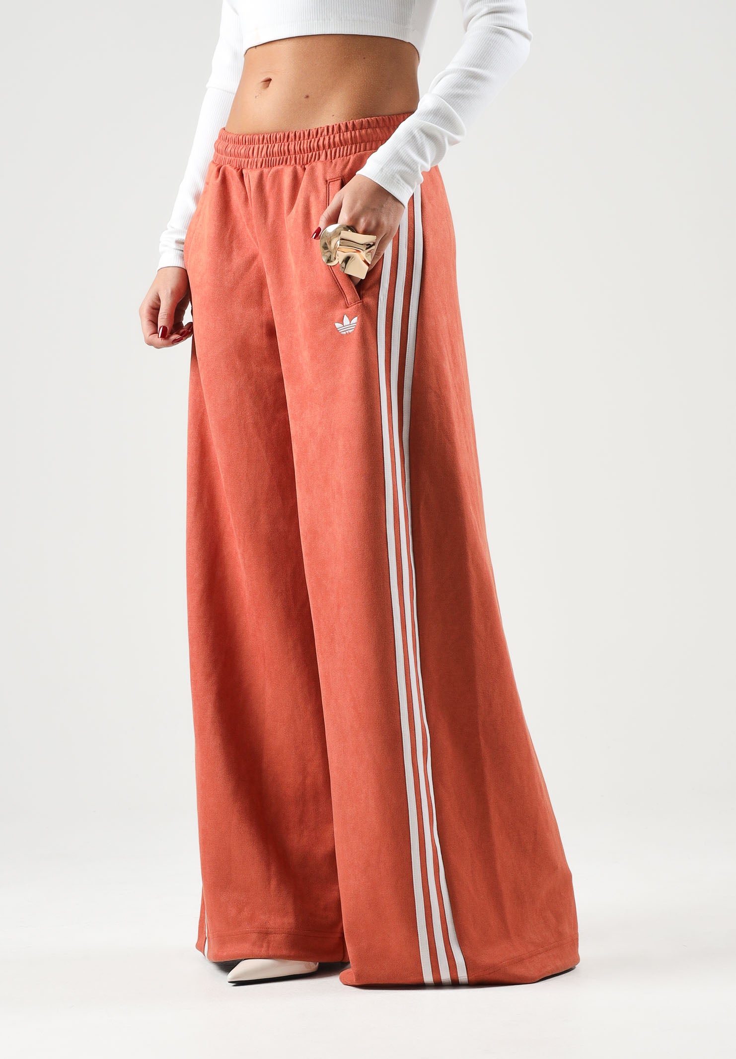 ADIDAS ORIGINALS Pantaloni ADILENIUM SEASON 6 FAUX SUEDE TRACK PANT arancione terracotta da donna, in tessuto effetto camoscio sintetico, con tre strisce laterali a contrasto e gamba ampia. LH1926 . ADIDAS ORIGINALS 