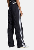 ADIDAS ORIGINALS Pantaloni ADILENIUM SEASON 6 RUFFLED Black neri da donna, in tessuto tecnico con gamba ampia, arricciature e bande laterali. LH1930 . ADIDAS ORIGINALS 