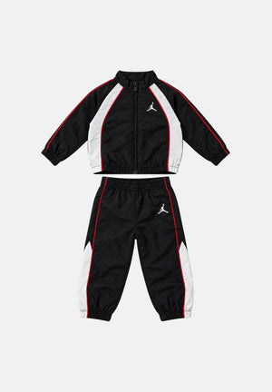 JORDAN Tuta neonato WIND CB PIPING Black nera da bambino, in tessuto tecnico, composta da giacca con collo alto, zip frontale e pantaloni coordinati, con profili rossi e bianchi a contrasto e logo Jumpman. 65G286 023 JORDAN 