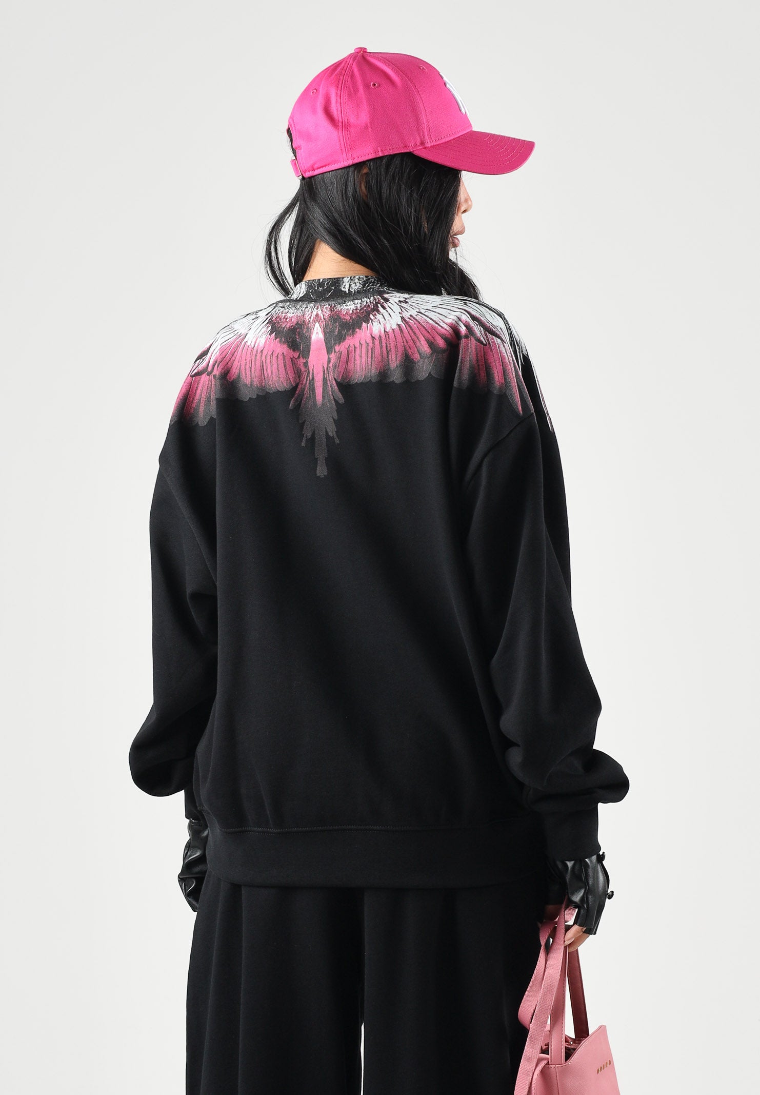 MARCELO BURLON COUNTY OF MILAN Felpa girocollo WINGS nera per donna con stampa ali fucsia e nere sulle spalle. 26ICM30205 NE MARCELO BURLON COUNTY OF MILAN 