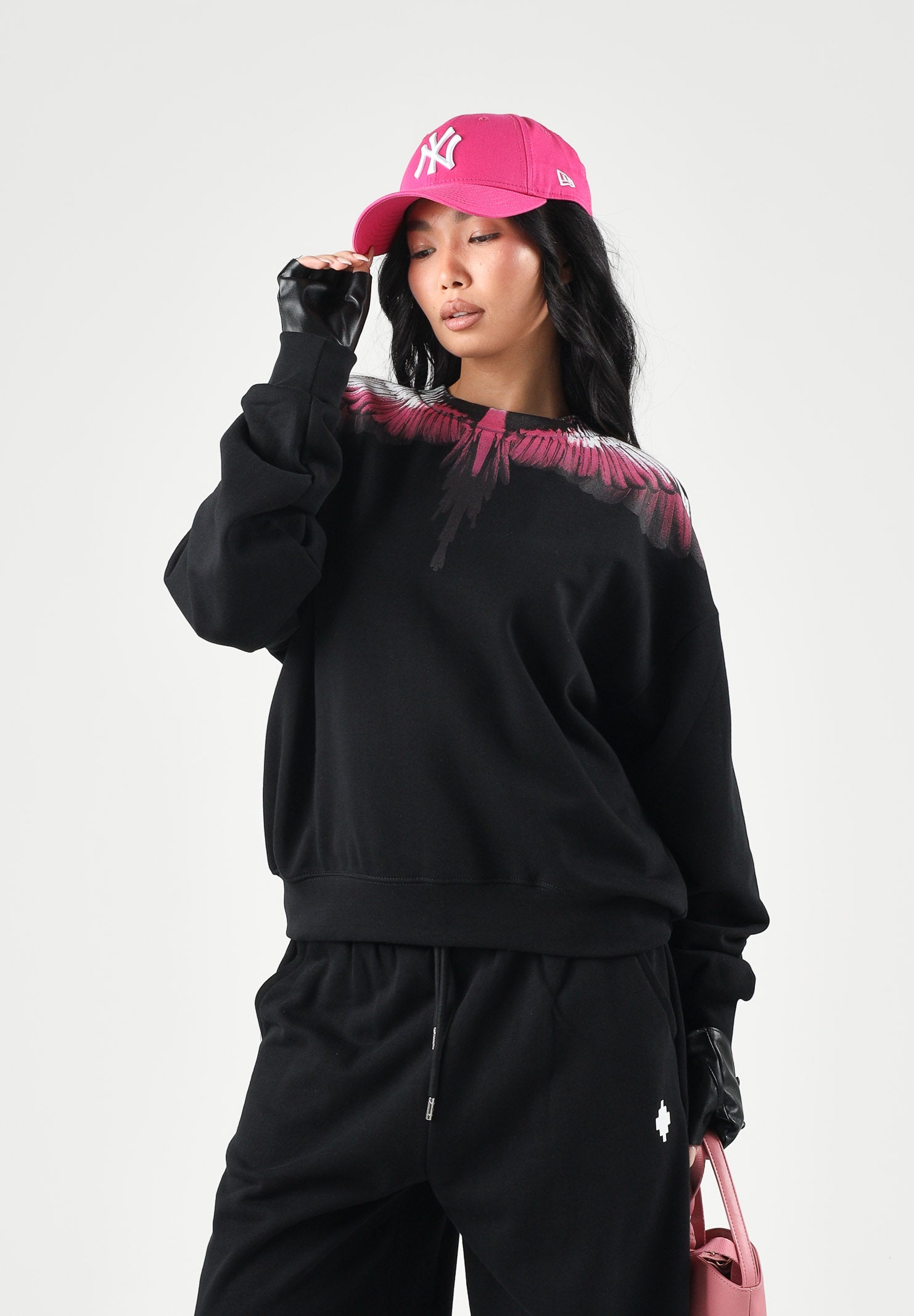 MARCELO BURLON COUNTY OF MILAN Felpa girocollo WINGS nera per donna con stampa ali fucsia e nere sulle spalle. 26ICM30205 NE MARCELO BURLON COUNTY OF MILAN 