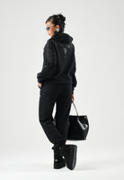 MARCELO BURLON COUNTY OF MILAN Pantaloni jogger neri per donna e ragazza con coulisse regolabile e logo frontale. F6CMJBFP051 110 MARCELO BURLON COUNTY OF MILAN 