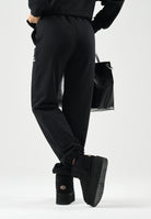 MARCELO BURLON COUNTY OF MILAN Pantaloni jogger neri per donna e ragazza con coulisse regolabile e logo frontale. F6CMJBFP051 110 MARCELO BURLON COUNTY OF MILAN 