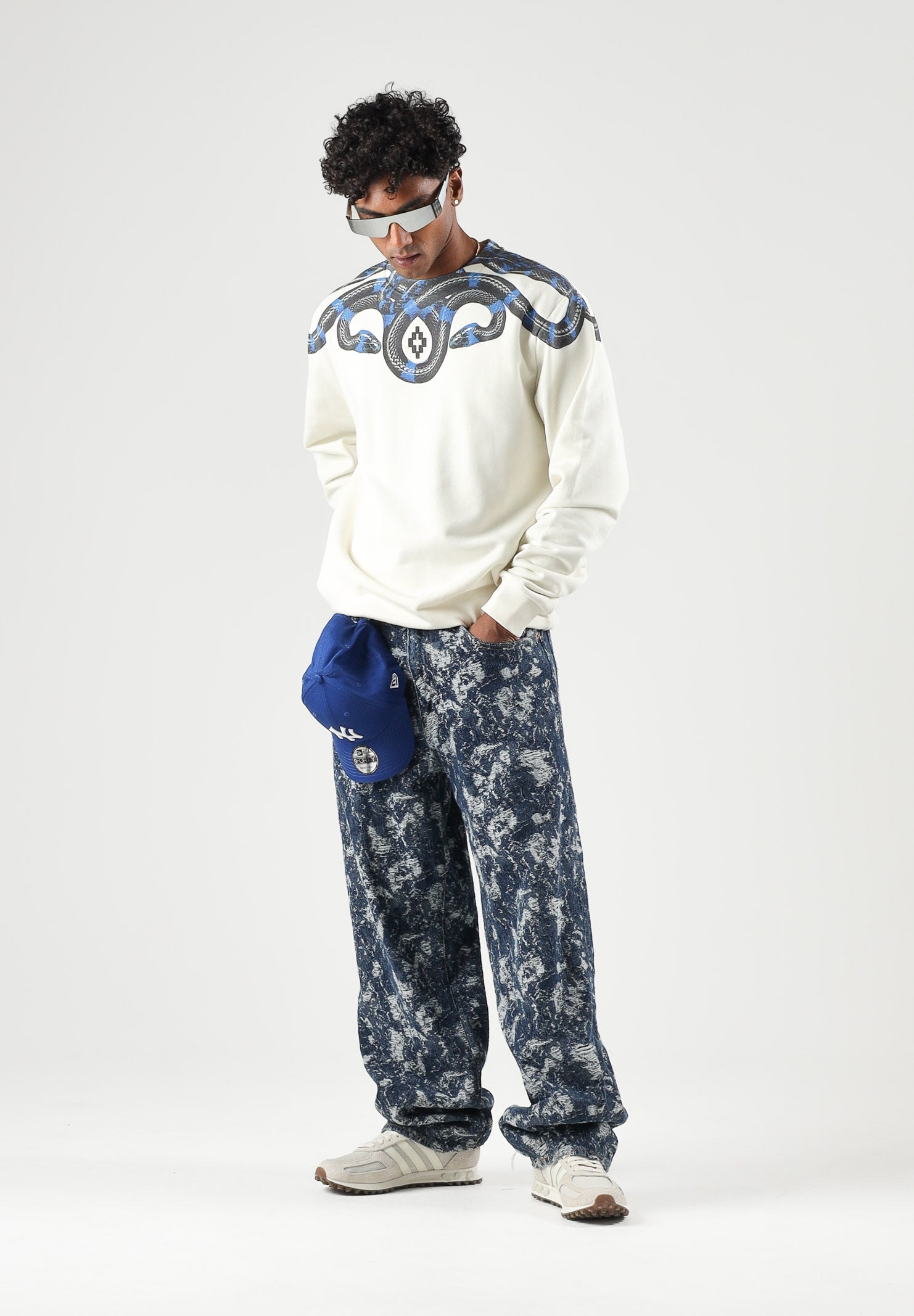 MARCELO BURLON COUNTY OF MILAN felpa girocollo WINGS cocco bianco panna da uomo in morbido cotone felpato, caratterizzata dall'iconica stampa geometrica ad ali di serpente nei toni del blu e nero, disposta intorno al girocollo e sulle spalle, maniche F6CMMASW115 412 MARCELO BURLON COUNTY OF MILAN 