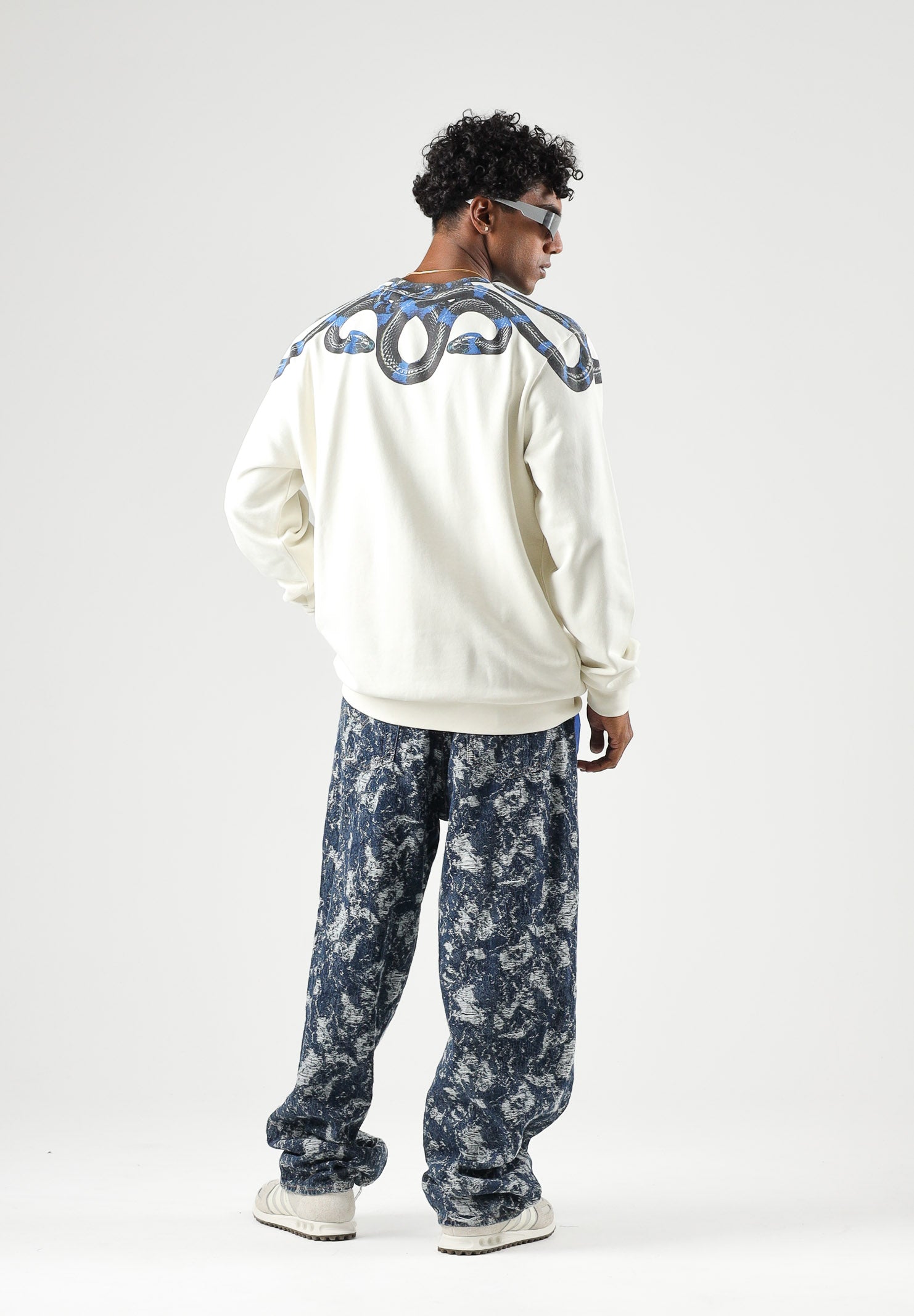 MARCELO BURLON COUNTY OF MILAN felpa girocollo WINGS cocco bianco panna da uomo in morbido cotone felpato, caratterizzata dall'iconica stampa geometrica ad ali di serpente nei toni del blu e nero, disposta intorno al girocollo e sulle spalle, maniche F6CMMASW115 412 MARCELO BURLON COUNTY OF MILAN 