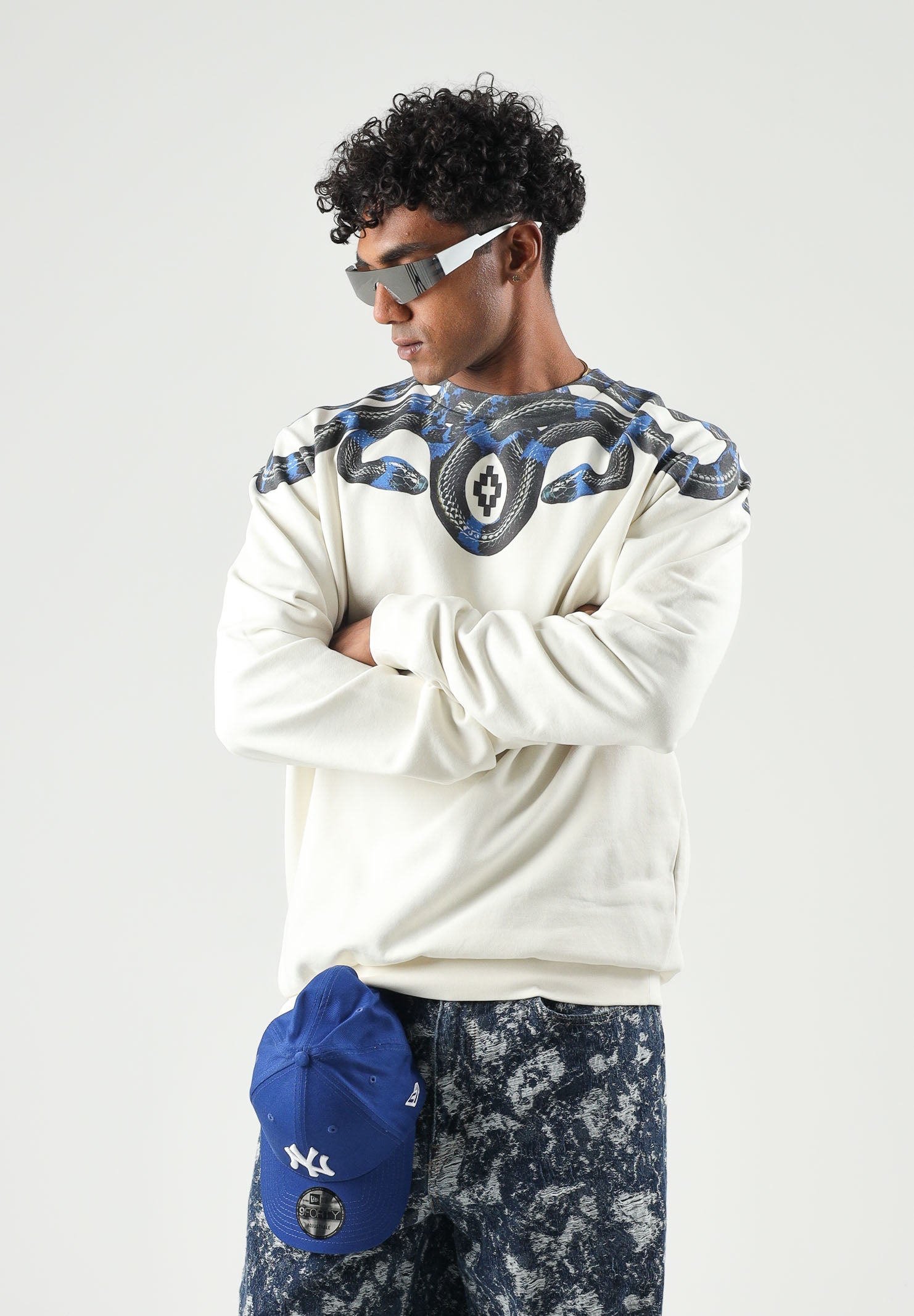 MARCELO BURLON COUNTY OF MILAN felpa girocollo WINGS cocco bianco panna da uomo in morbido cotone felpato, caratterizzata dall'iconica stampa geometrica ad ali di serpente nei toni del blu e nero, disposta intorno al girocollo e sulle spalle, maniche F6CMMASW115 412 MARCELO BURLON COUNTY OF MILAN 