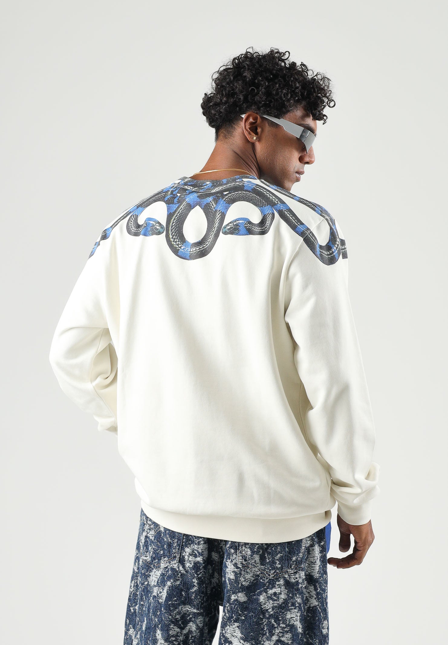 MARCELO BURLON COUNTY OF MILAN felpa girocollo WINGS cocco bianco panna da uomo in morbido cotone felpato, caratterizzata dall'iconica stampa geometrica ad ali di serpente nei toni del blu e nero, disposta intorno al girocollo e sulle spalle, maniche F6CMMASW115 412 MARCELO BURLON COUNTY OF MILAN 