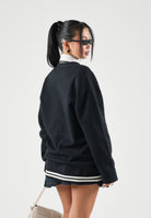 NEW ERA Cardigan nero per uomo e donna con dettagli grafici e ricami lettering in perfetto stile college 60897473 . NEW ERA 