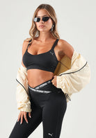 PUMA Top sportivo MID IMPACT nero da donna con spalline incrociate sul retro e logo cat riflettente. 529062 01 PUMA 