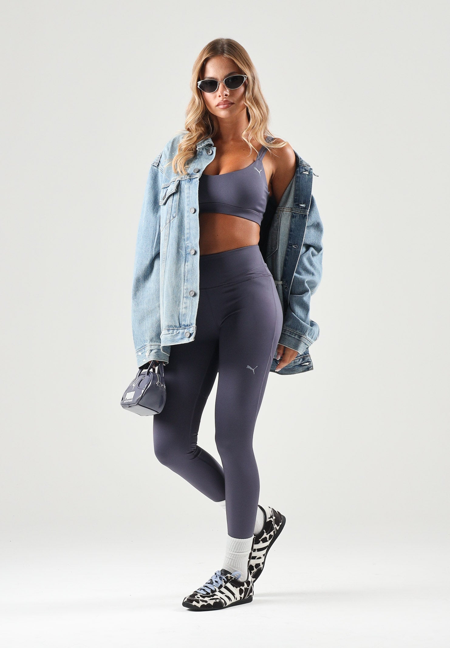 PUMA Top sportivo MID IMPACT grigio da donna con spalline incrociate sul retro e logo cat riflettente. 529062 35 PUMA 