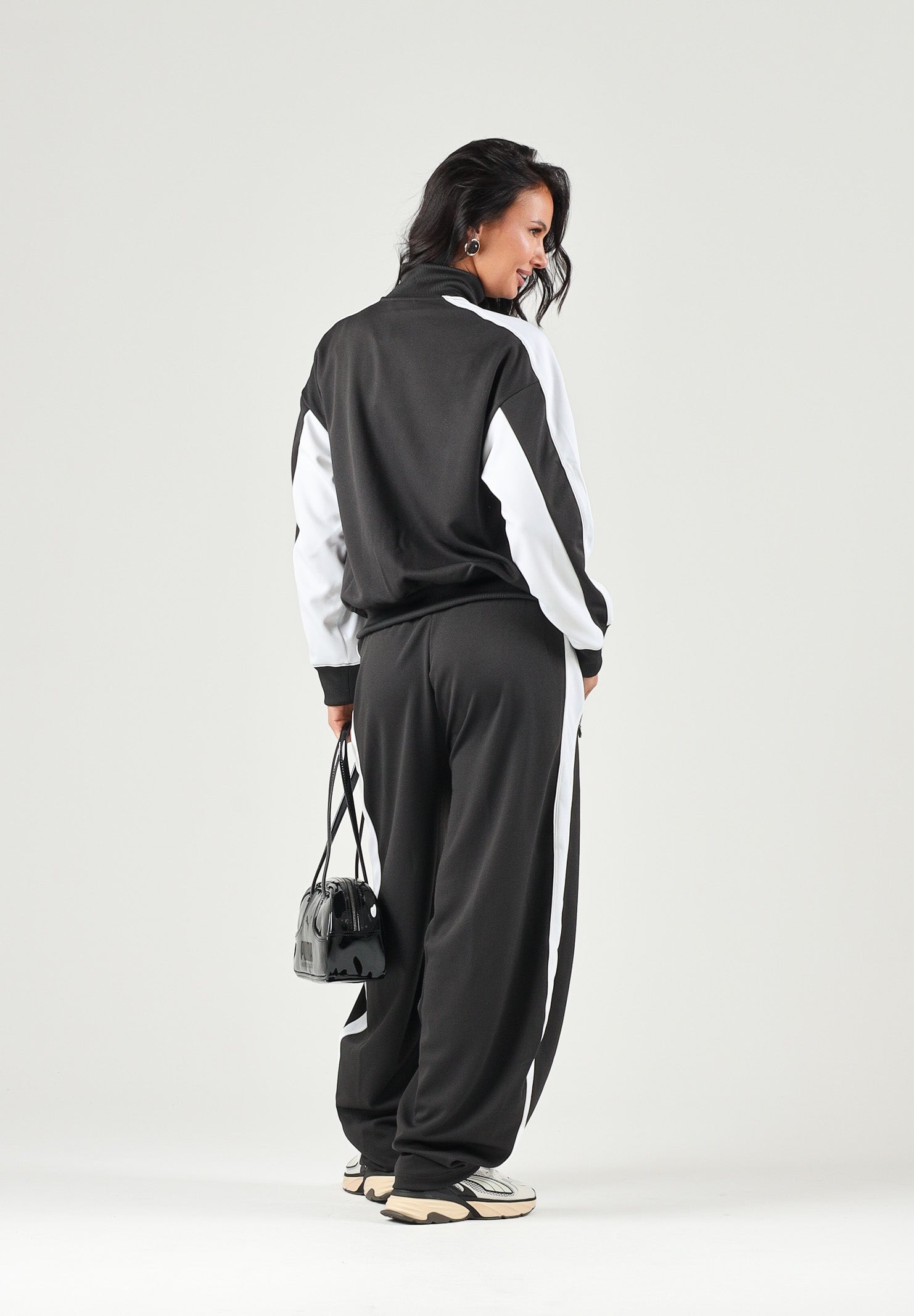 PUMA Pantalone DARE TO WOVEN nero per donna con bande laterali bianche, tasche zippate e gamba ampia. 636633 01 PUMA 