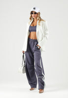 PUMA Pantalone DARE TO WOVEN grigio antracite per donna con bande laterali bianche, tasche zippate e gamba ampia. 636633 35 PUMA 