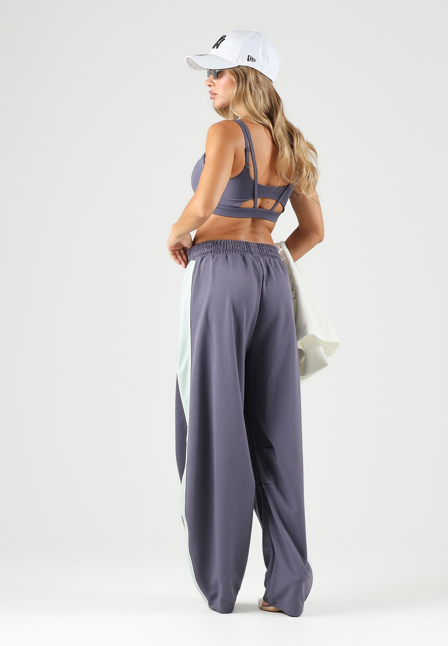 PUMA Pantalone DARE TO WOVEN grigio antracite per donna con bande laterali bianche, tasche zippate e gamba ampia. 636633 35 PUMA 