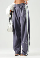 PUMA Pantalone DARE TO WOVEN grigio antracite per donna con bande laterali bianche, tasche zippate e gamba ampia. 636633 35 PUMA 