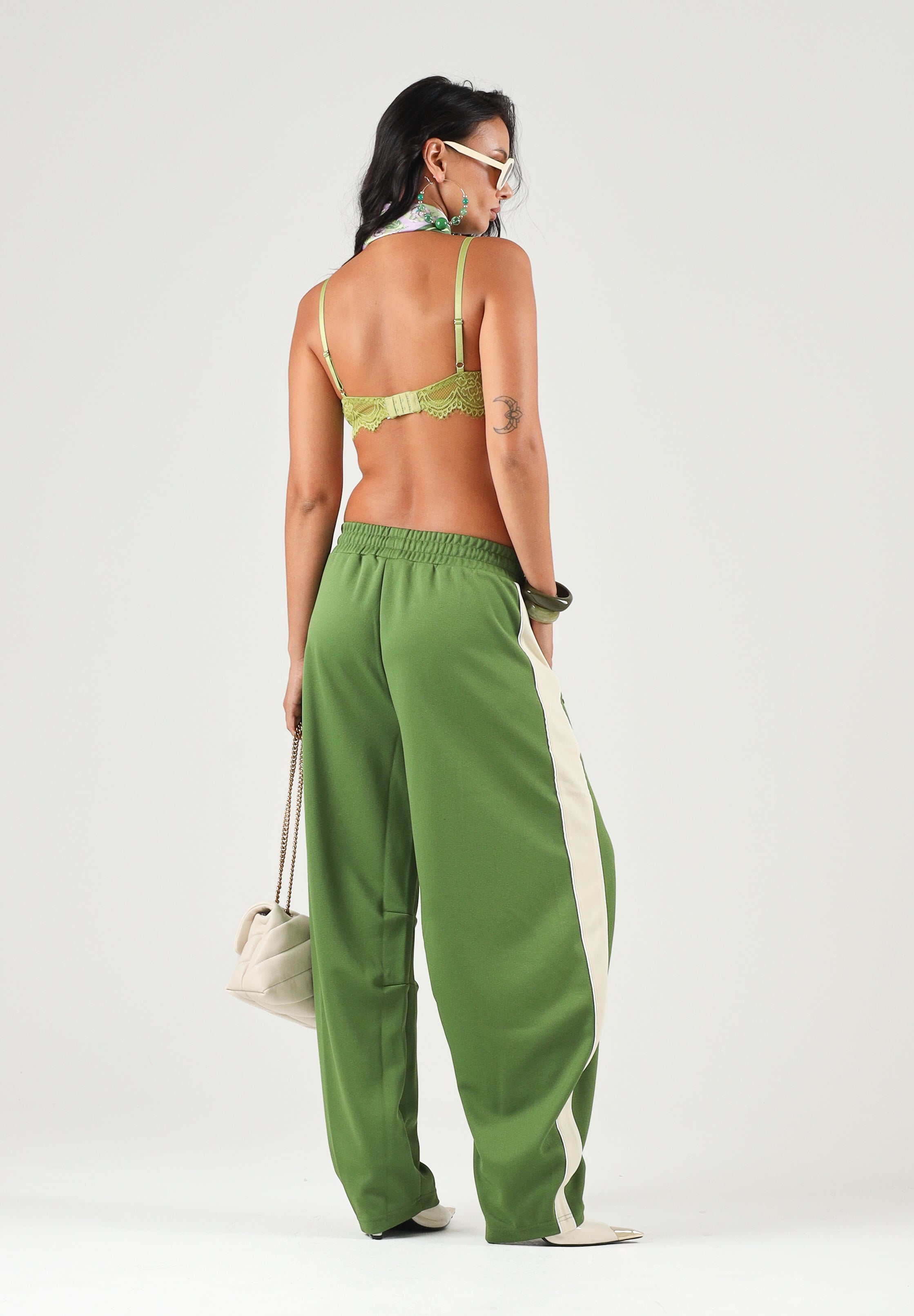 PUMA Pantalone DARE TO WOVEN verde per donna con bande laterali bianche, tasche zippate e gamba ampia. 636633 68 PUMA 