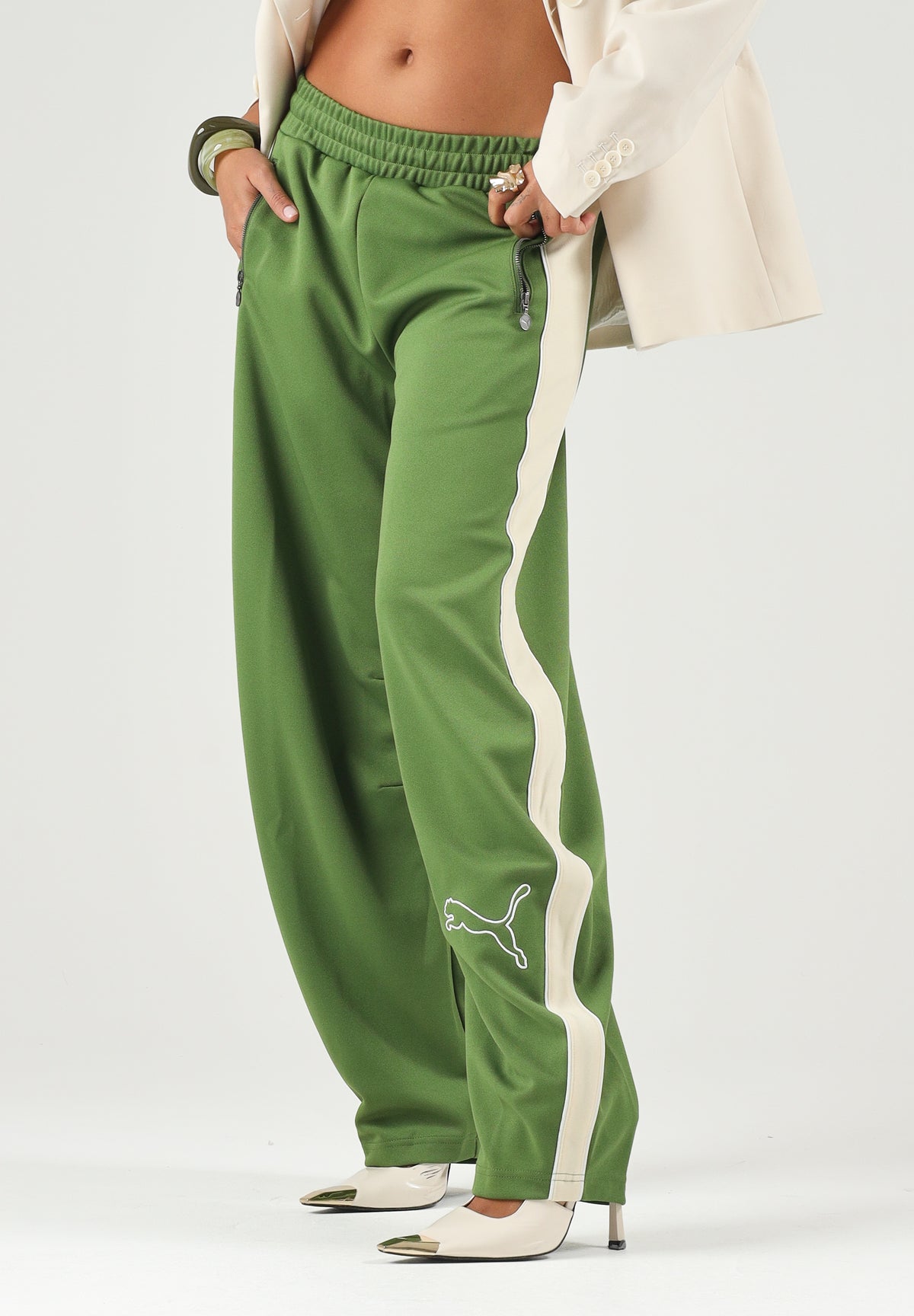 PUMA Pantalone DARE TO WOVEN verde per donna con bande laterali bianche, tasche zippate e gamba ampia. 636633 68 PUMA 