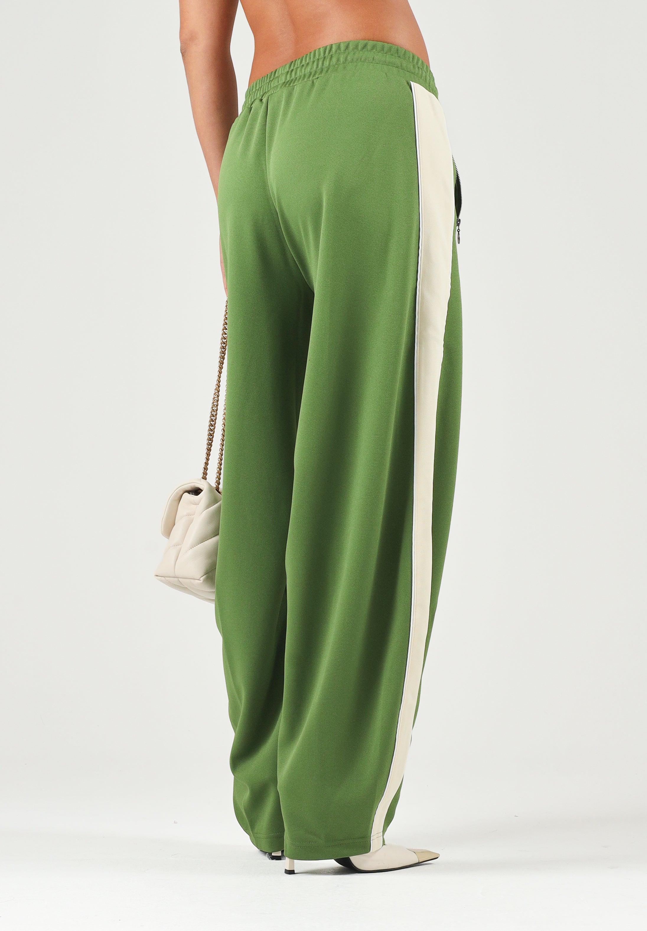PUMA Pantalone DARE TO WOVEN verde per donna con bande laterali bianche, tasche zippate e gamba ampia. 636633 68 PUMA 