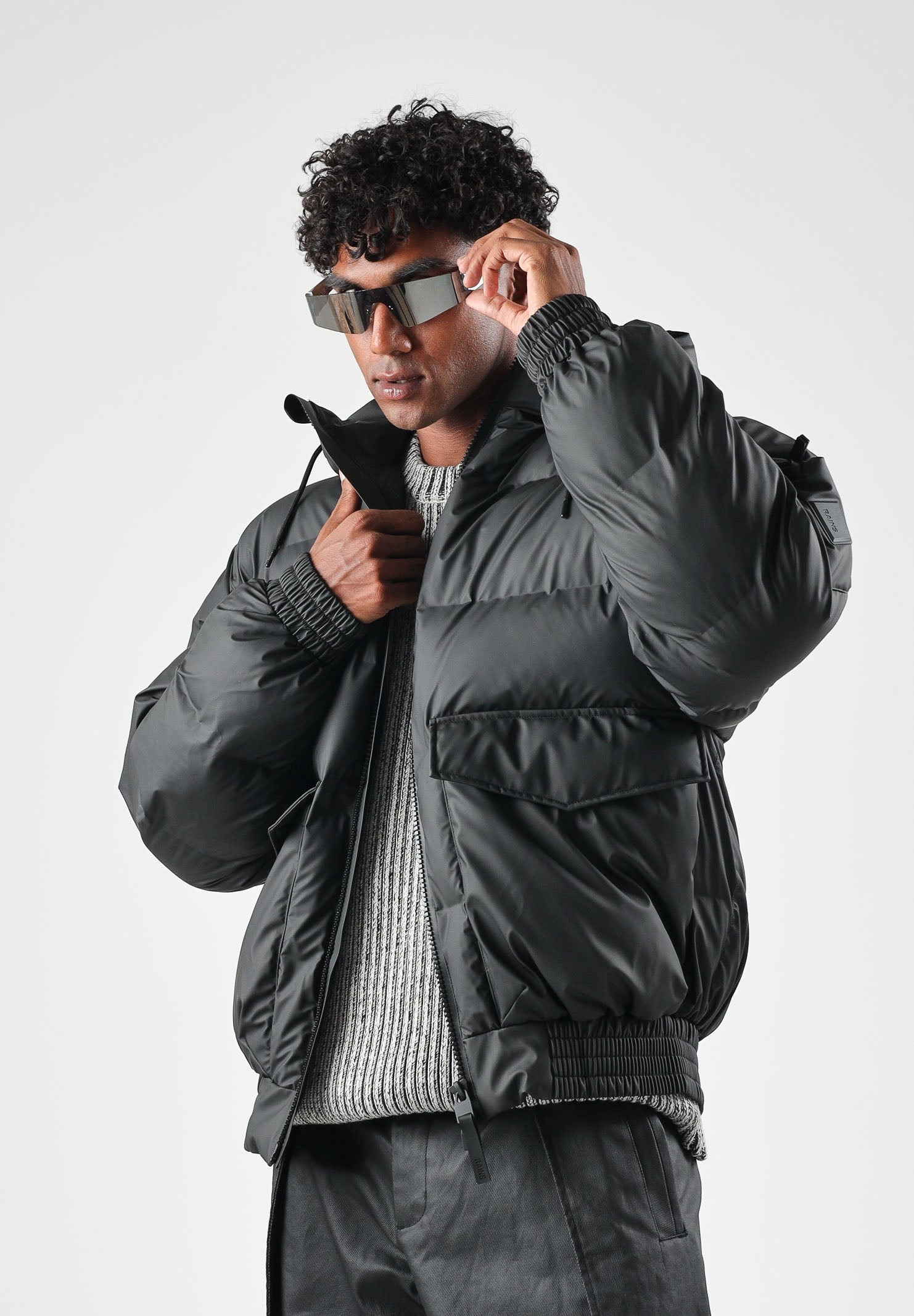 RAINS Piumino nero per uomo e donna con cappuccio regolabile e chiusura full zip impermeabile. RA16990 BL RAINS 