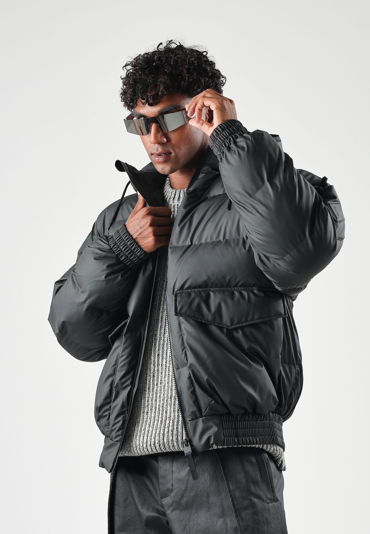 RAINS Piumino nero per uomo e donna con cappuccio regolabile e chiusura full zip impermeabile. RA16990 BL RAINS 
