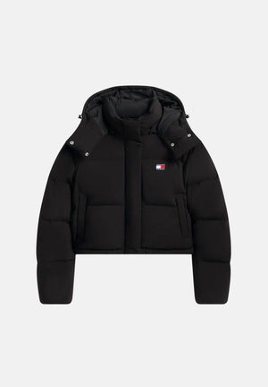 TOMMY JEANS Piumino corto DOWN RELAXED ALASKA PUFFER JACKET Black nero da donna, con imbottitura in vera piuma naturale, cappuccio, collo alto, chiusura frontale con zip e trapuntatura a pannelli orizzontali. DW0DW18609 BDS TOMMY JEANS 
