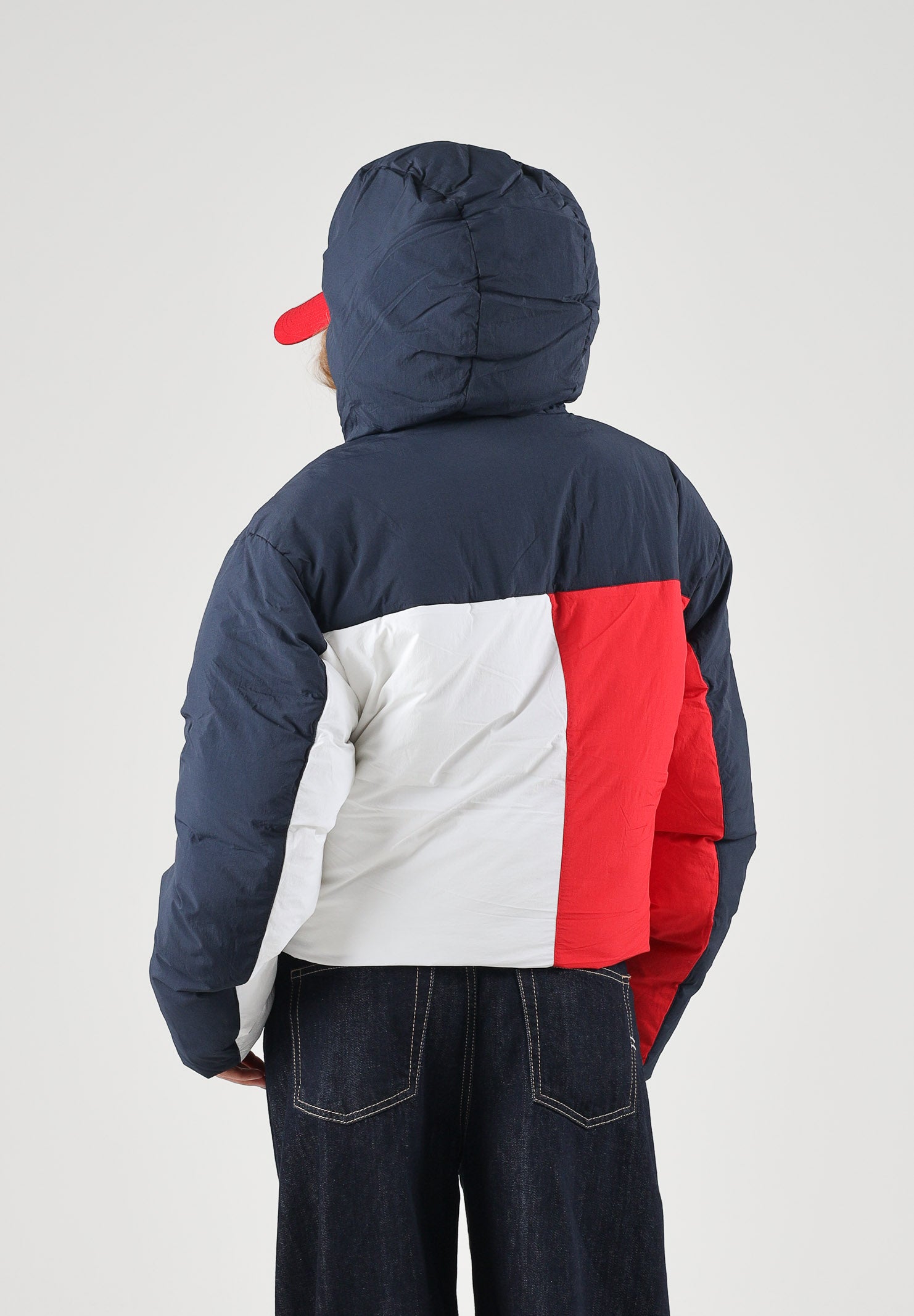 TOMMY JEANS Piumino  FLAG COLOUR-BLOCKED Dark Blue blu navy scuro da donna con inserti bianchi e rossi, cappuccio integrato, imbottitura sintetica, zip frontale integrale, tasche laterali con zip e fondo regolabile con coulisse.TOMMY JEANS Giubbotto  DW0DW23414 C1G TOMMY JEANS 