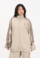 ADIDAS ORIGINALS Giacca a vento Firebird Adilenium beige da donna KD6297 . ADIDAS ORIGINALS 