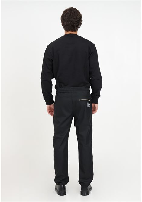 Pantaloni neri con coulisse e targhetta logo da uomo VERSACE JEANS COUTURE | Pantaloni | 75GAA100N0220899