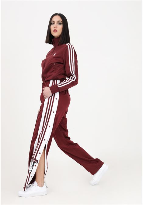 Women's burgundy sporty trousers with buttons on the legs ADIDAS | IB7297.