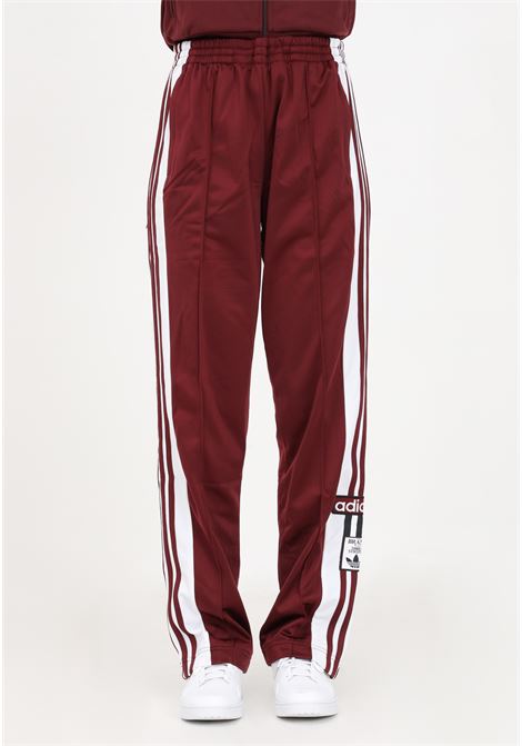 Women's burgundy sporty trousers with buttons on the legs ADIDAS | IB7297.