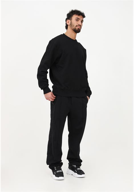Pantalone casual nero da uomo con bande laterali logate VERSACE JEANS COUTURE | Pantaloni | 74GAA318F0010899