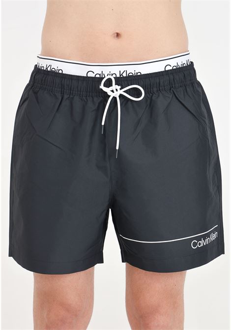 Black men's swim shorts with logo print and logoed elastic waistband CALVIN KLEIN | Beachwear | KM0KM00957BEH