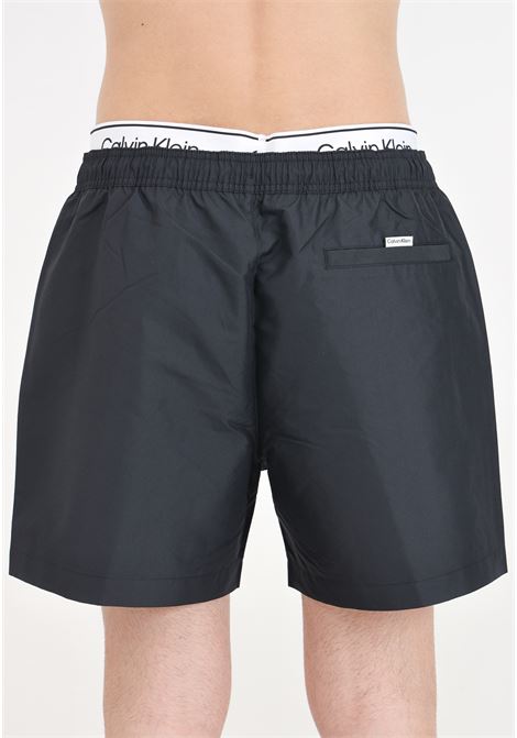 Black men's swim shorts with logo print and logoed elastic waistband CALVIN KLEIN | Beachwear | KM0KM00957BEH