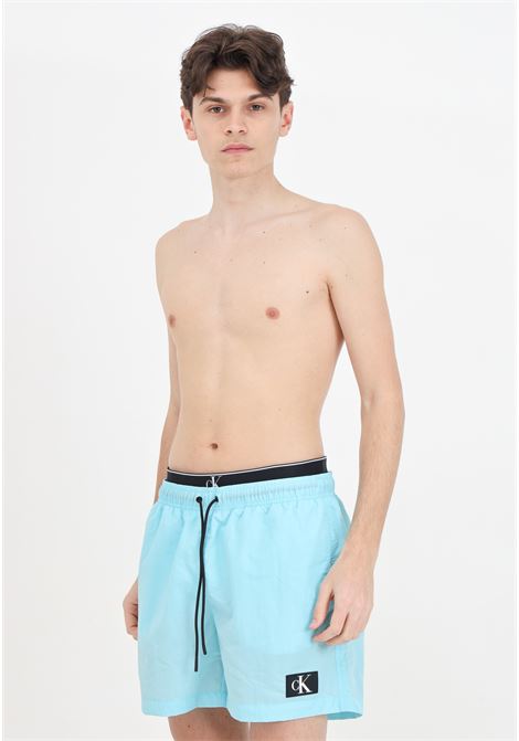 Shorts mare turchese da uomo con patch logo ed elastico modello slip CALVIN KLEIN | Beachwear | KM0KM00981CSY
