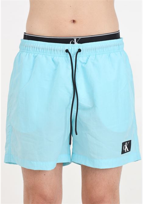 Turquoise men's swim shorts with logo patch and elasticated slip model CALVIN KLEIN | Beachwear | KM0KM00981CSY
