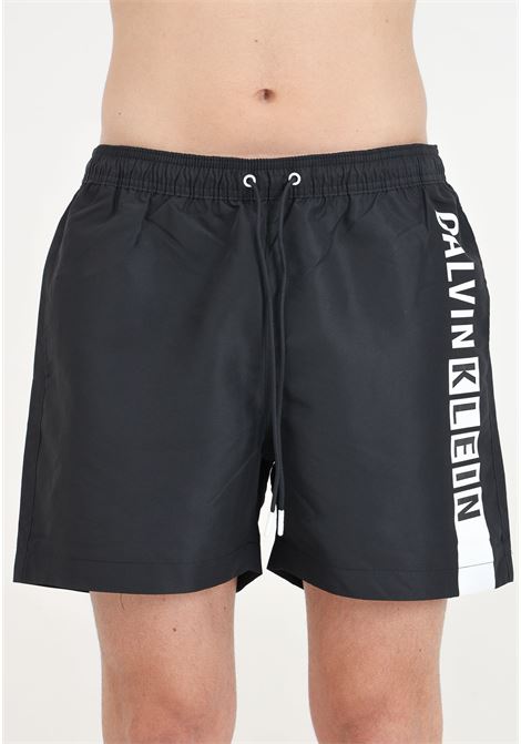 Shorts mare nero da uomo con maxi stampa logo CALVIN KLEIN | Beachwear | KM0KM00991BEH